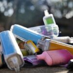 Collection of discarded vapes on a concrete background