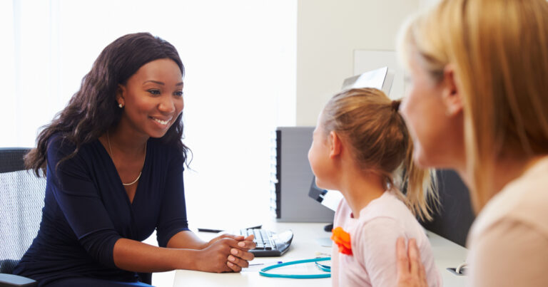 Mother And Daughter Visiting Doctor In Surgery