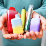 Schoolboy holding vapes in school