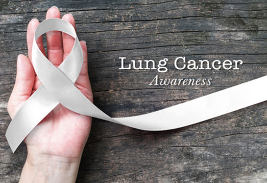 Lung cancer awareness month with white/ light pearl color ribbon on woman's hand support on aged wood