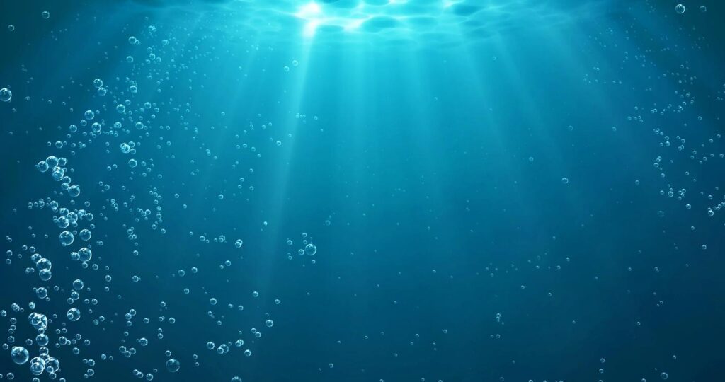 Underwater background with water bubbles and undersea light rays shine