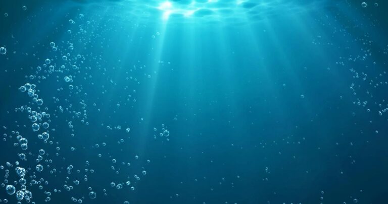 Underwater background with water bubbles and undersea light rays shine
